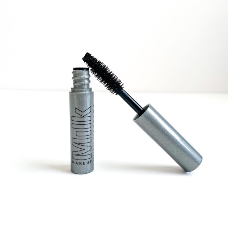 opened grey tube of mascara with mascara wand leaning against the side