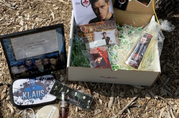 open mystic merch box on the ground with items around it