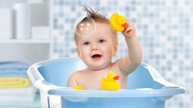 picture of baby in a bath with rubber duckies