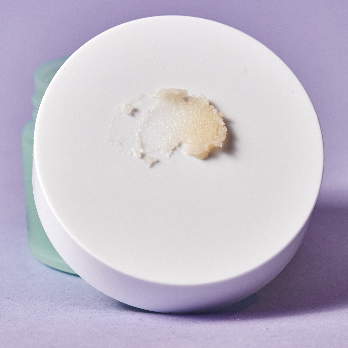 white lid of cleansing balm with texture of balm swiped on top