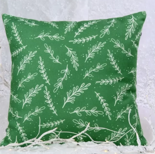 photo of green pillow with white plant accents