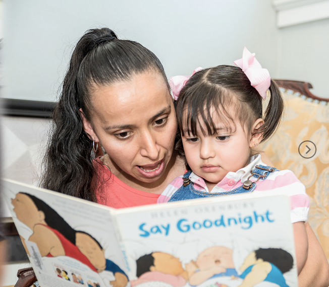 woman reading a book to a child