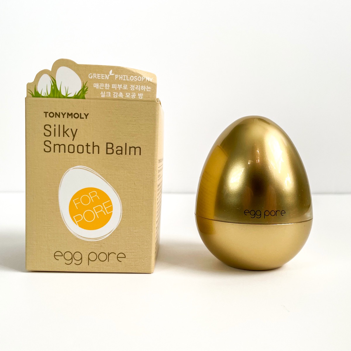 beige box with egg on it next to golden egg