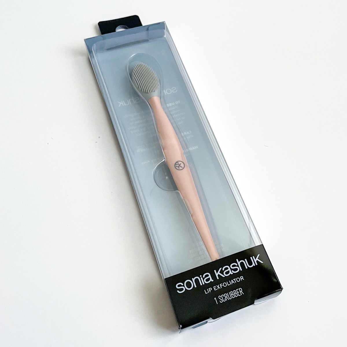 peach lip tool inside of clear and black plastic package