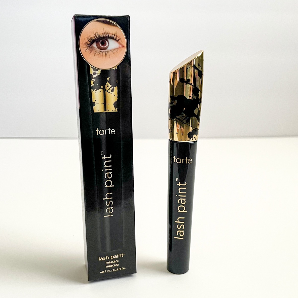 black and gold tube of mascara standing next to black and gold box