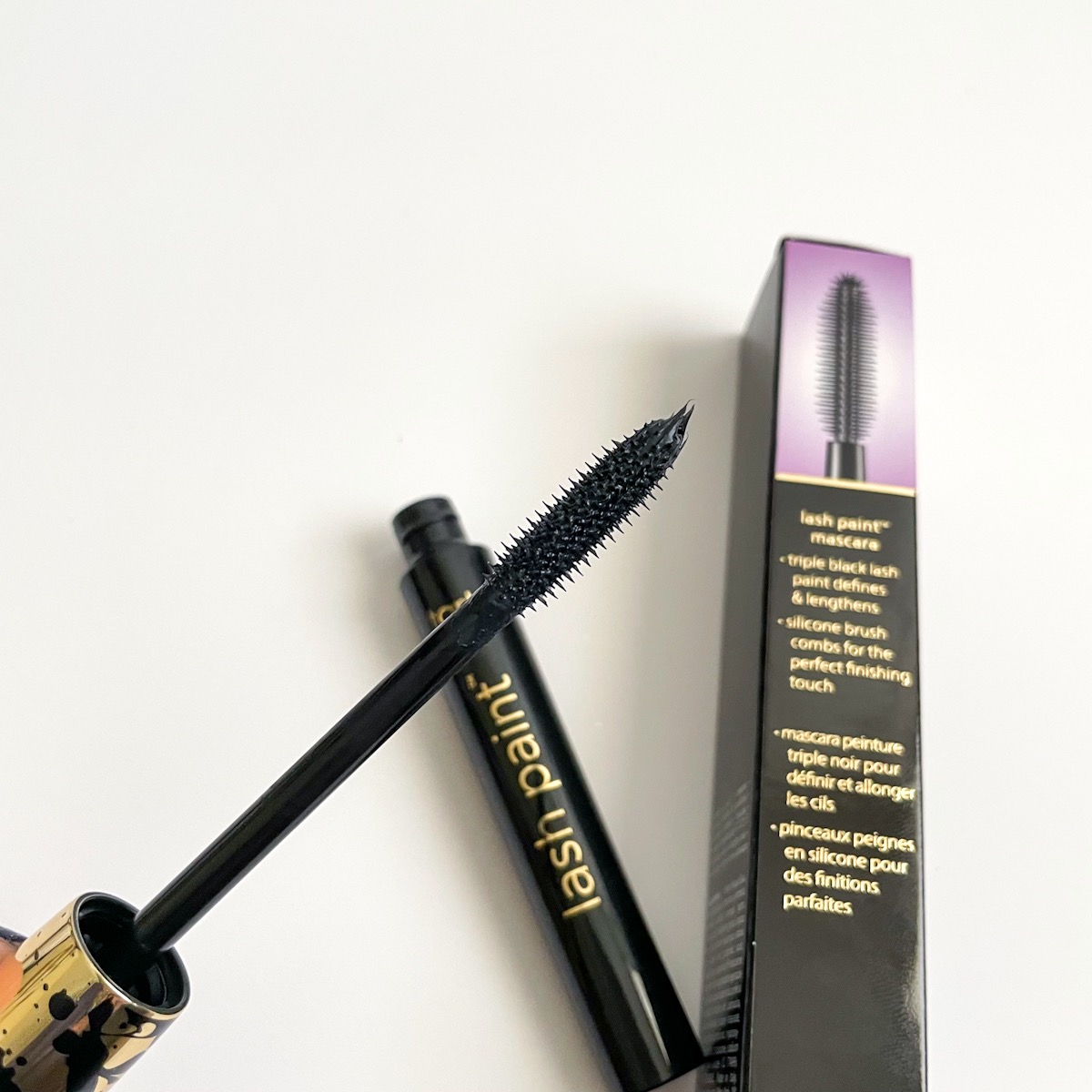 opened tube of black mascara showing black bristles