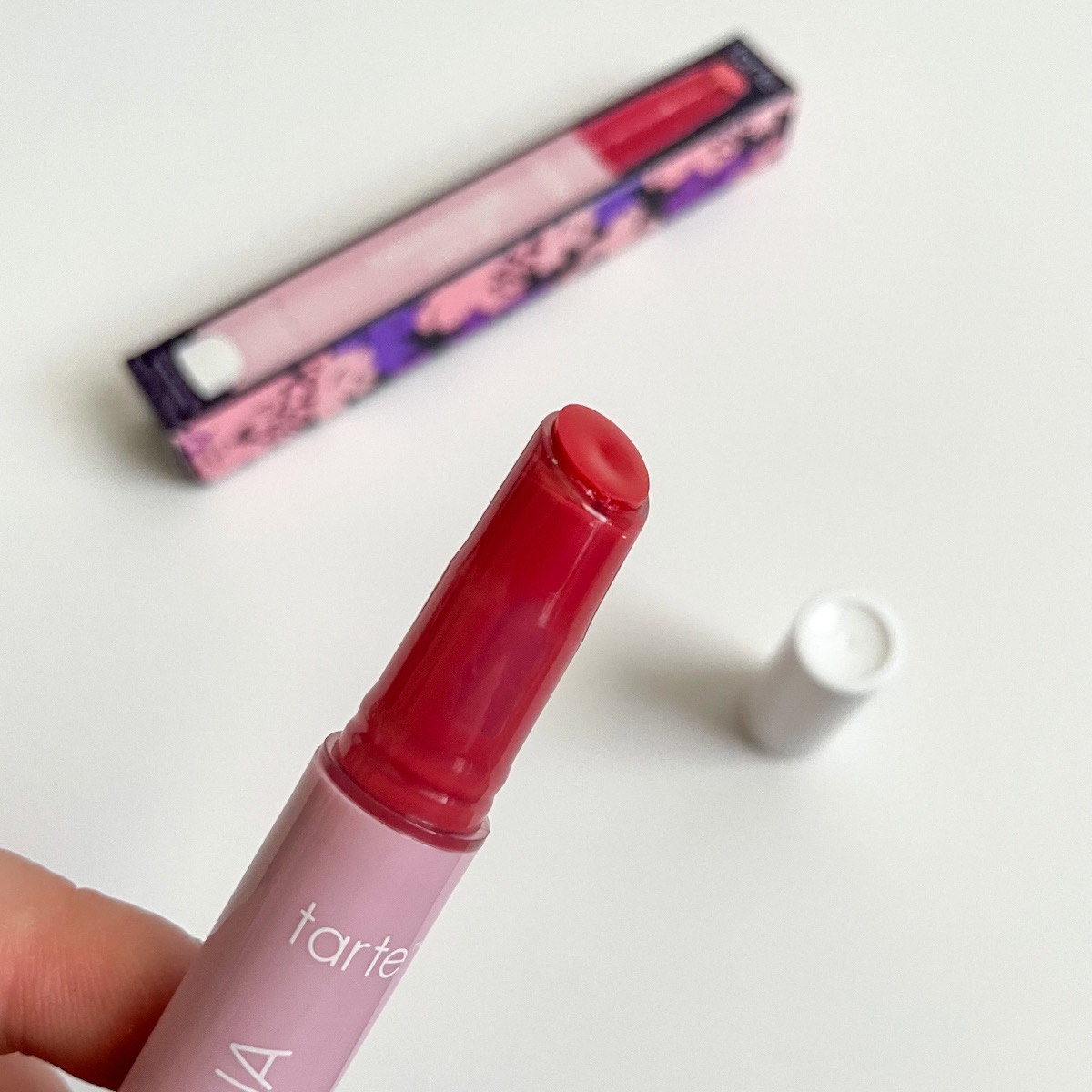 opened pink tube of lip balm showing strawberry texture