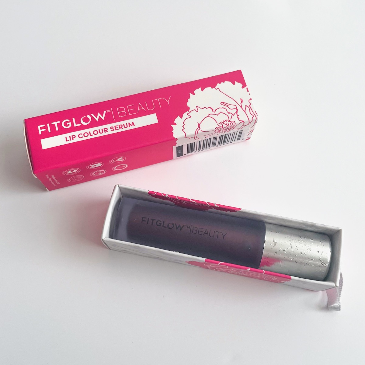 pink box, opened, showing deep berry lip serum