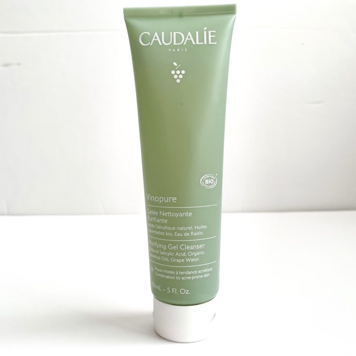 green tube of cleanser on white background