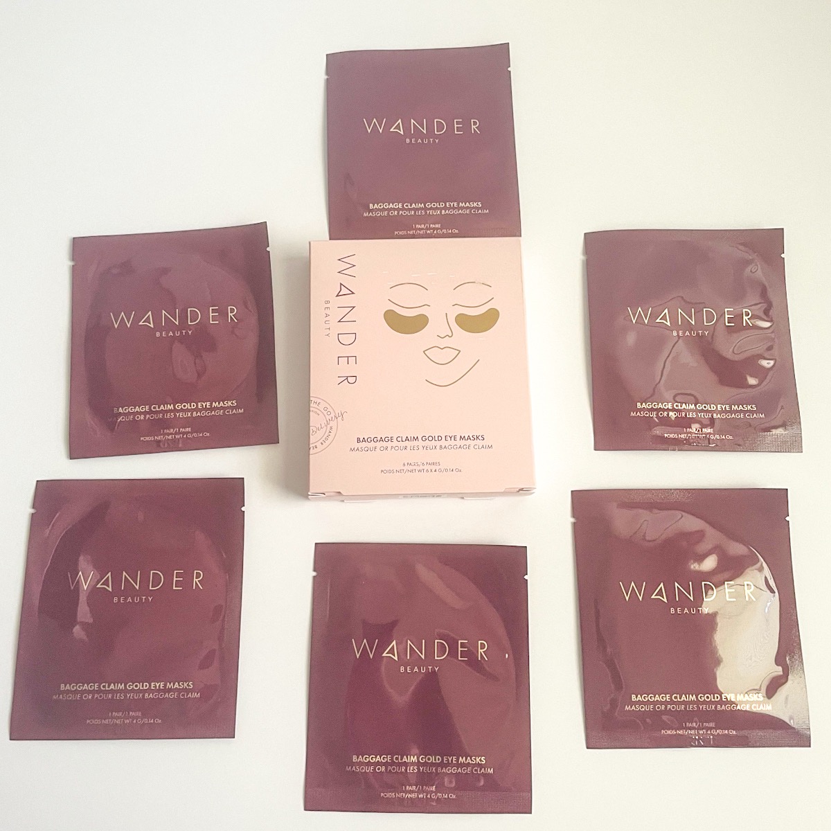 maroon eye mask packets surrounding pink and gold box