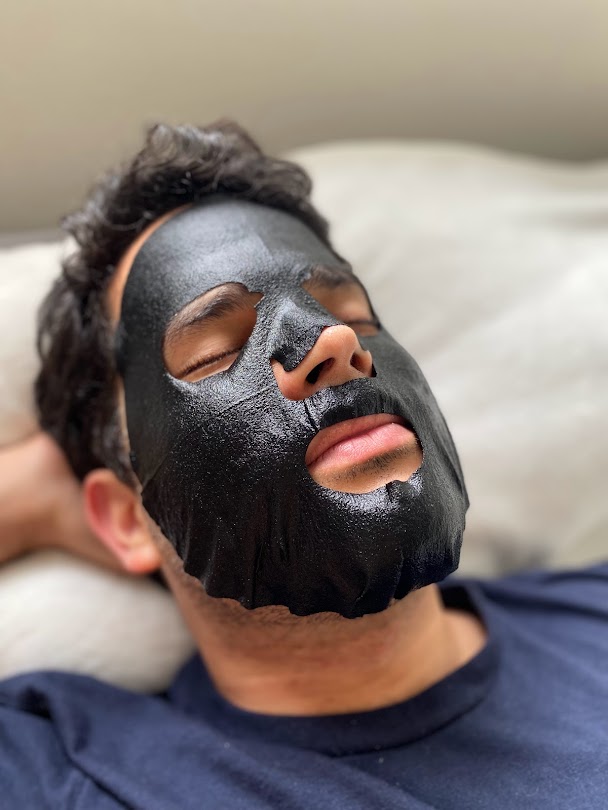 man using black sheet mask