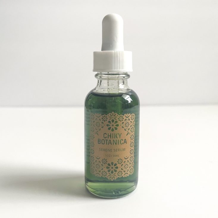 clear bottle with white top showing green serum and brown label