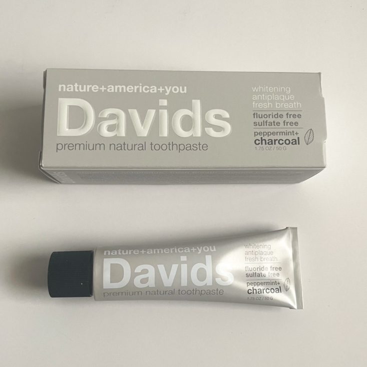 grey tube of toothpaste next to grey box