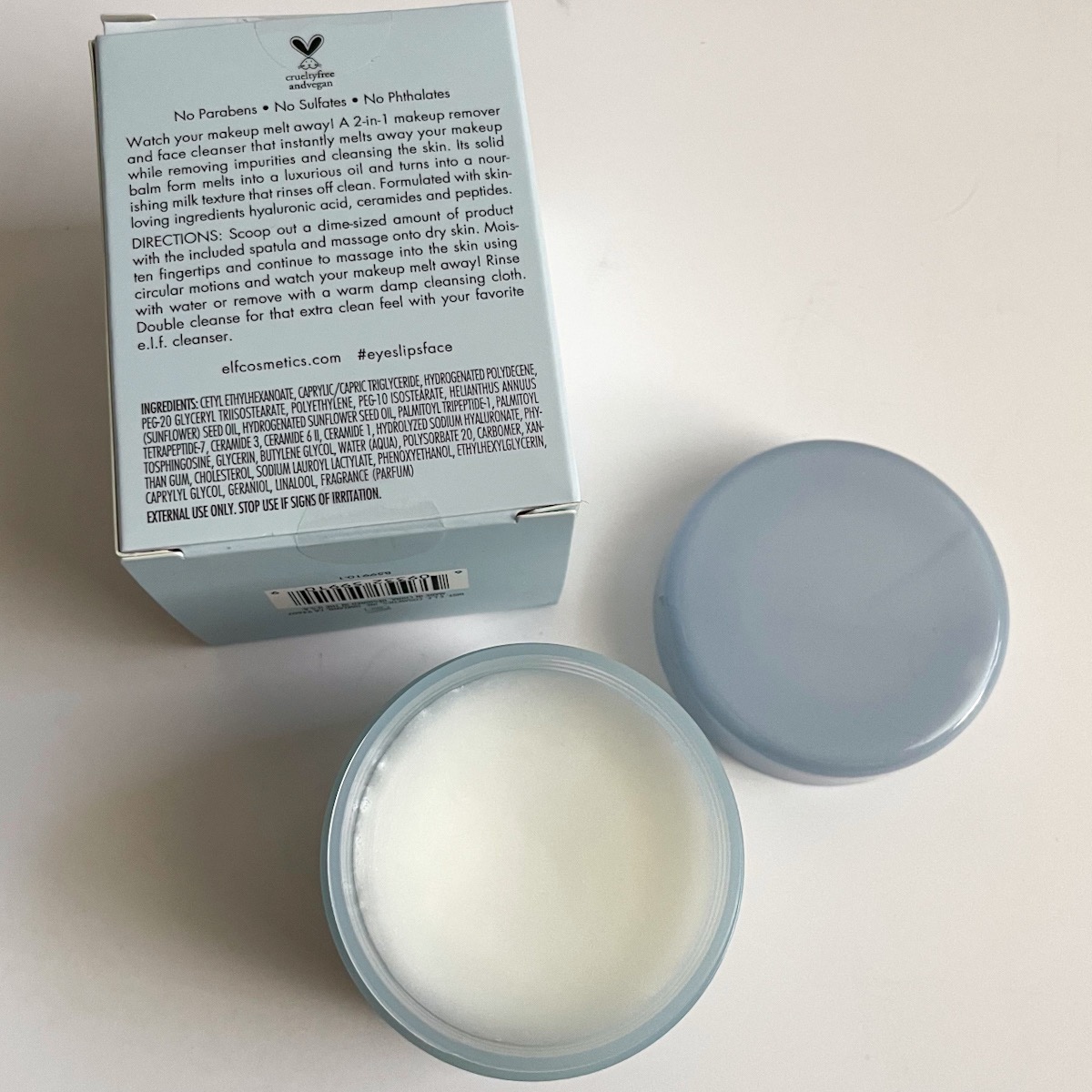 opened blue jar showing whit balm texture next to white blue box