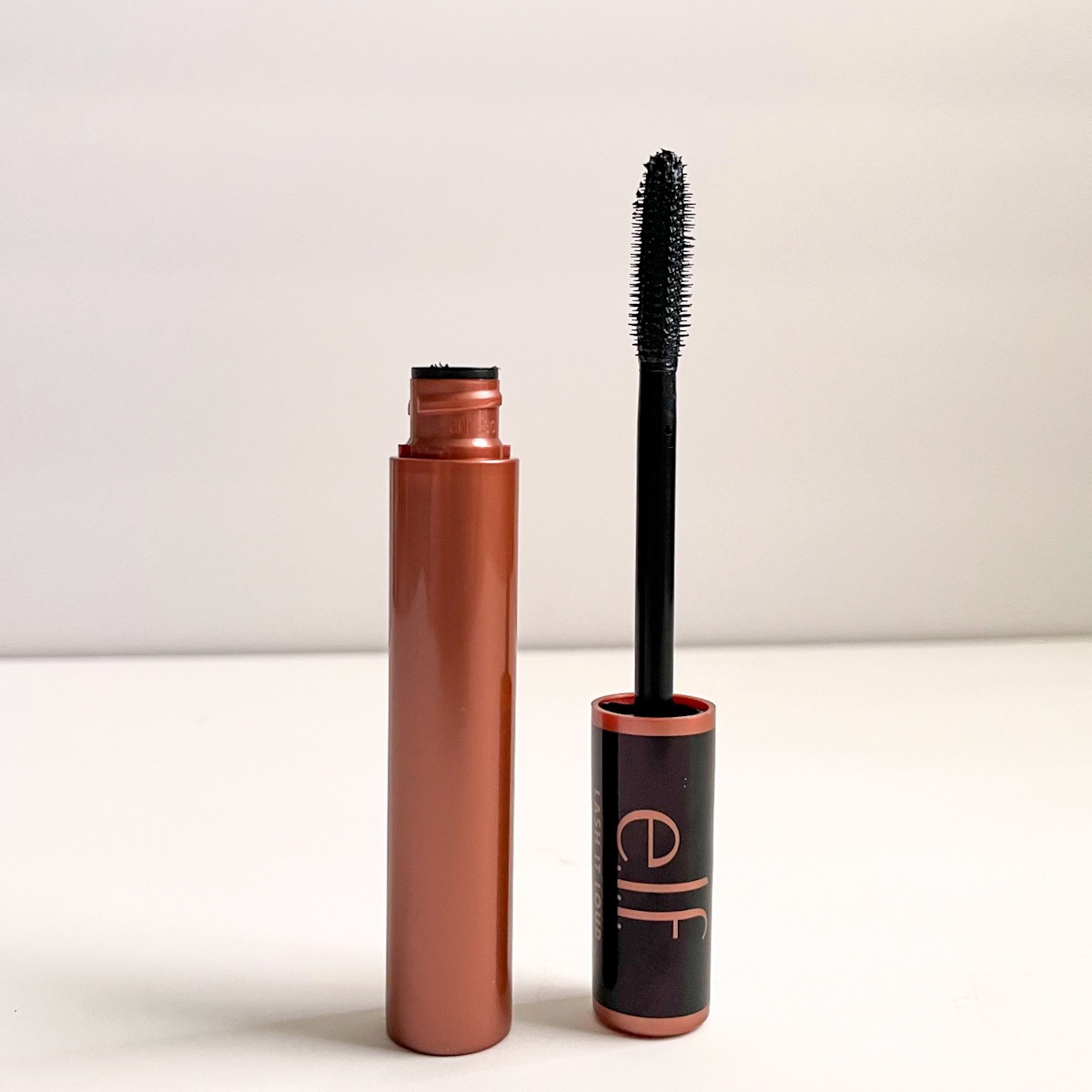 opened tube of mascara showing black mascara wand