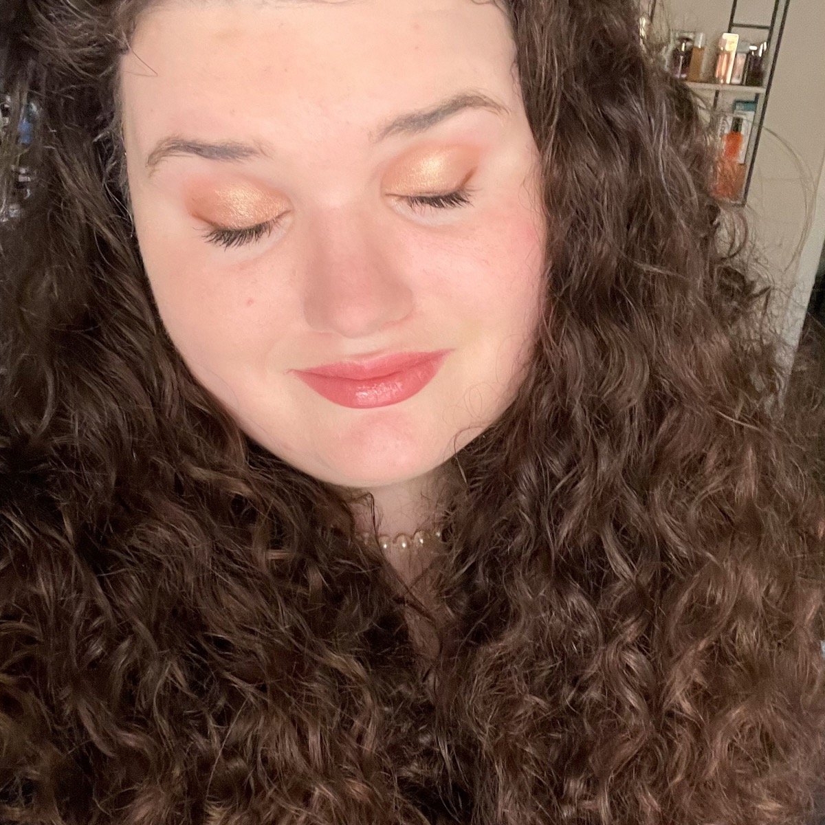 selfie wearing makeup products, eyes closed