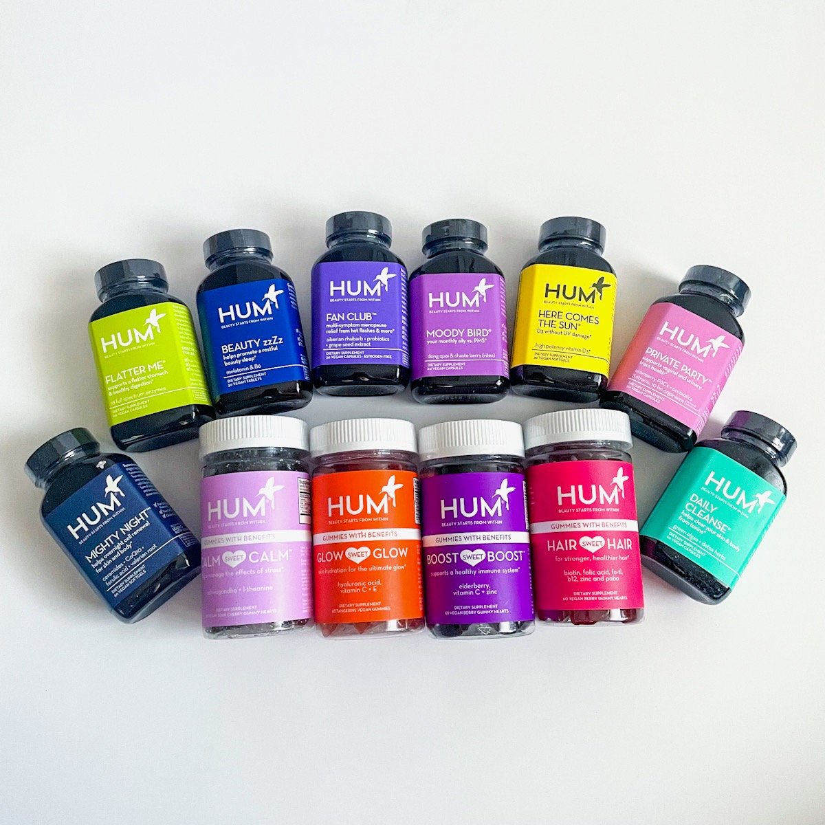 group shot of colorful bottles of supplements laying on white background