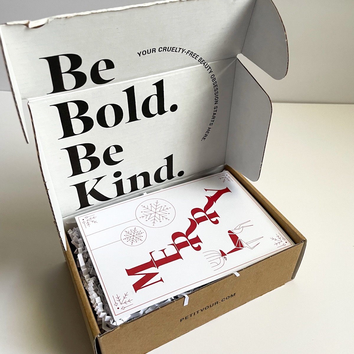 opened brown box with be bold be kind printed on lid