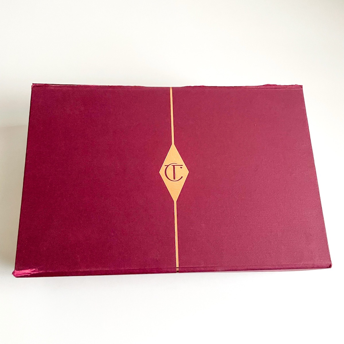 maroon box with gold accents on white background