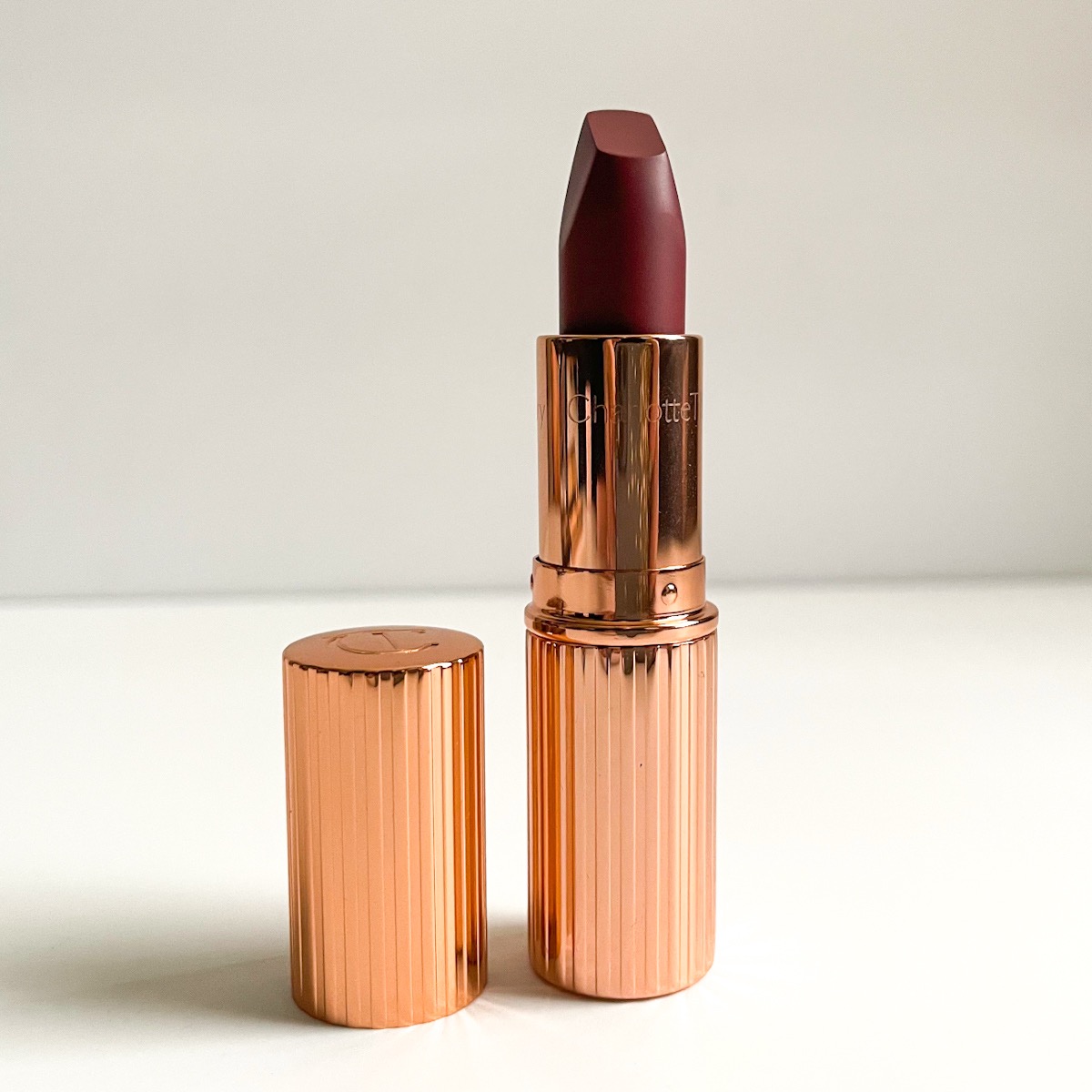 opened gold lipstick bullet showing berry lipstick shade