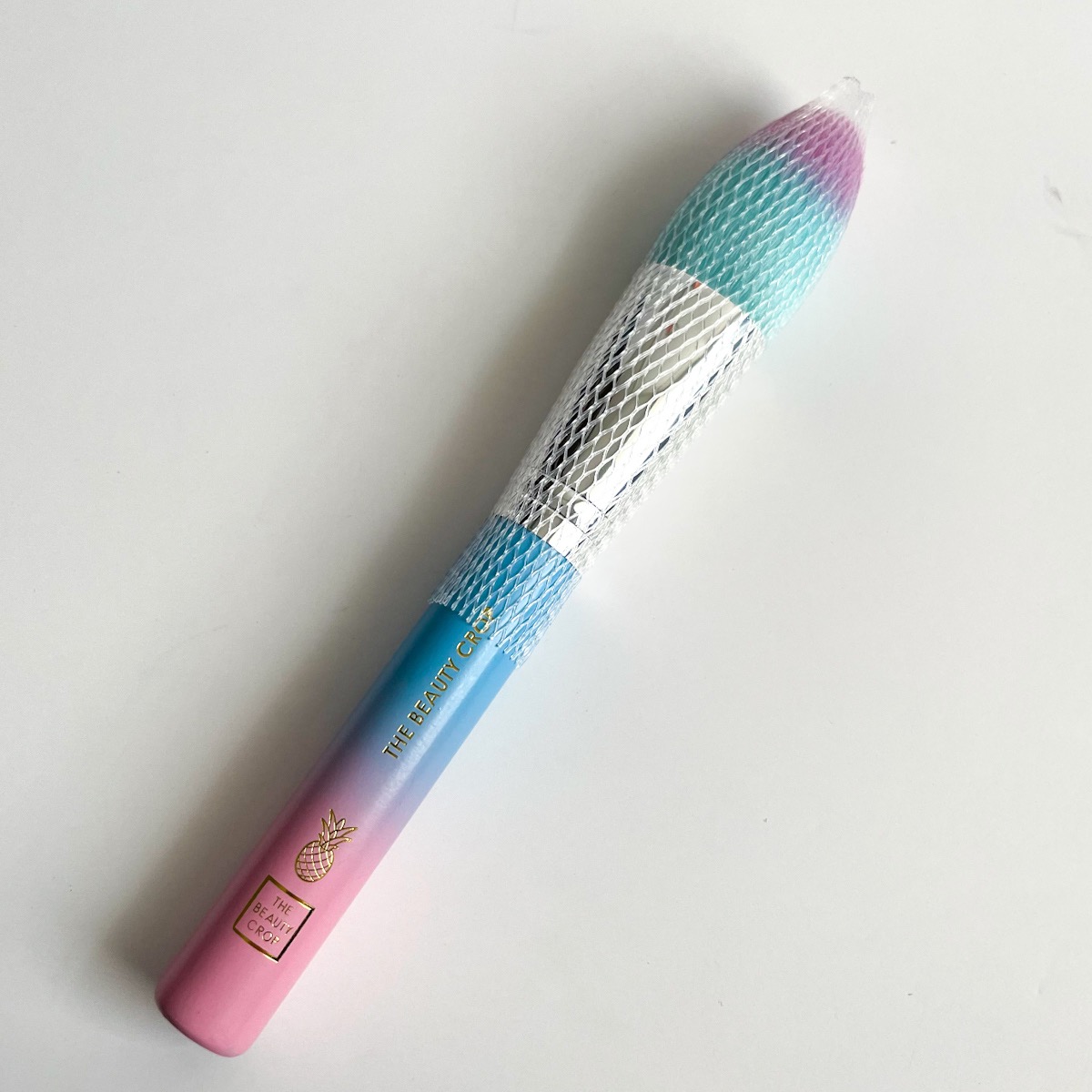 pink and blue ombre makeup brush with sleeve over bristles