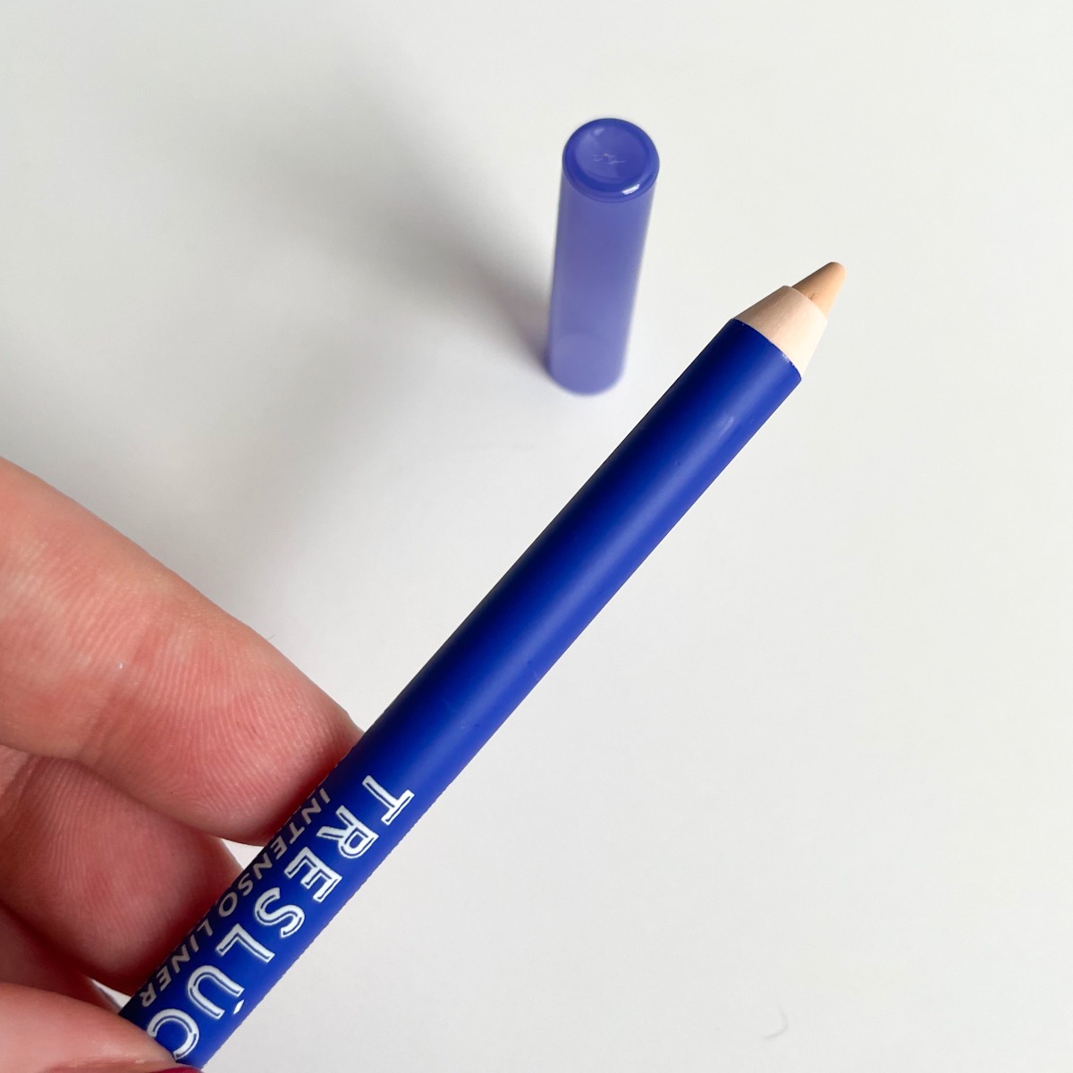 blue eyeshadow pencil with lid off showing beige eyeliner