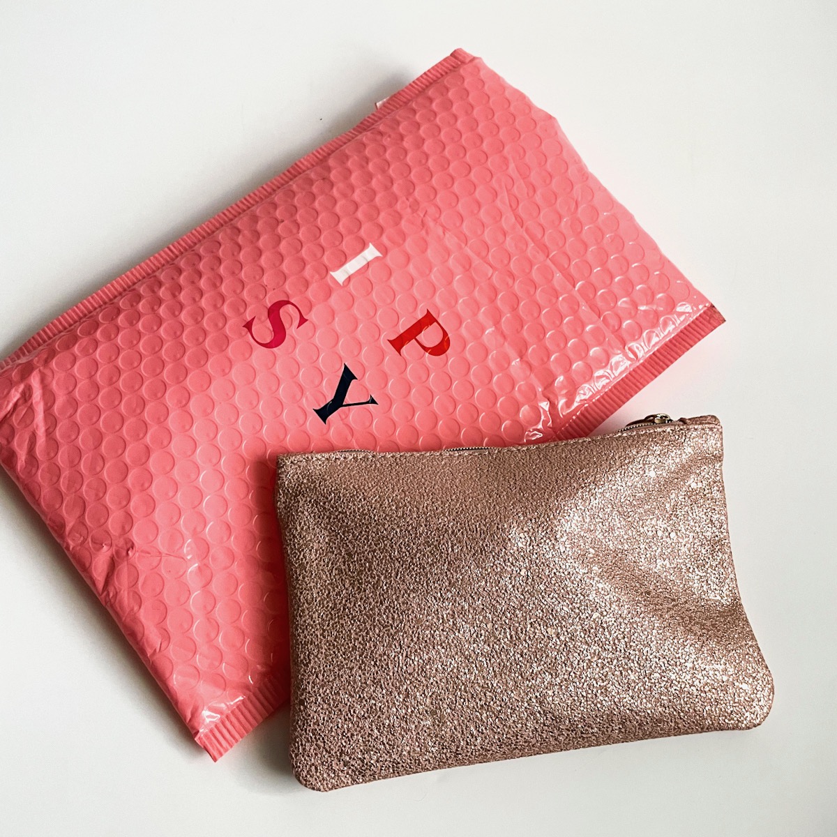 pink sparkly makeup bag with pink bubble mailer
