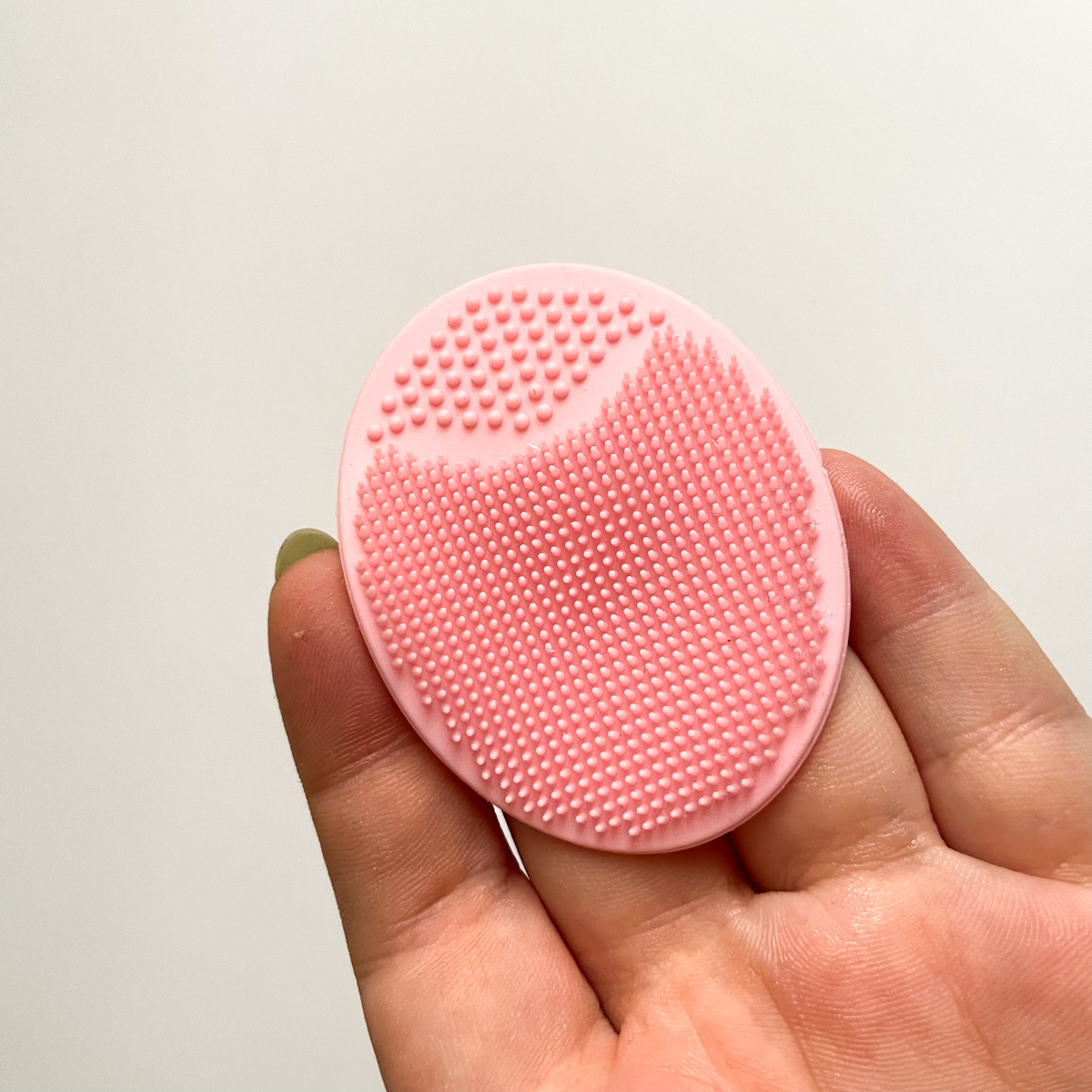 pink silicone scrubber held in hand