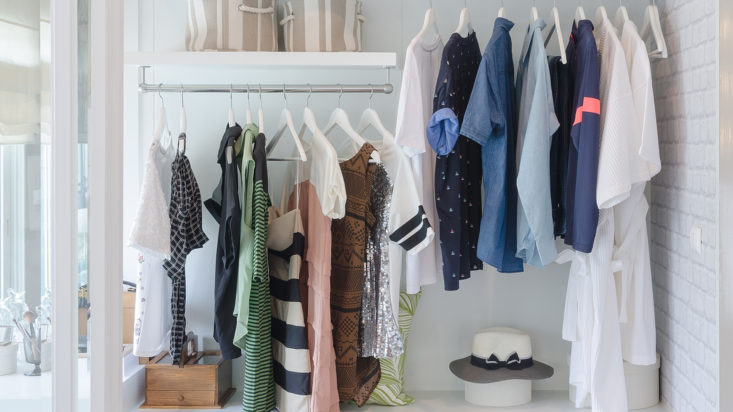 clothes hanging in closet with hat at home