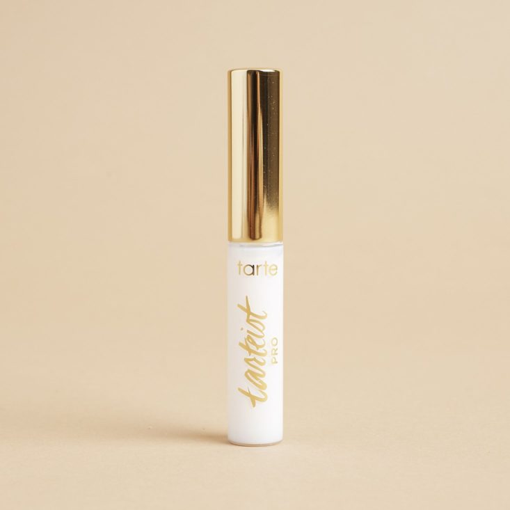 white and gold small tube on beige background