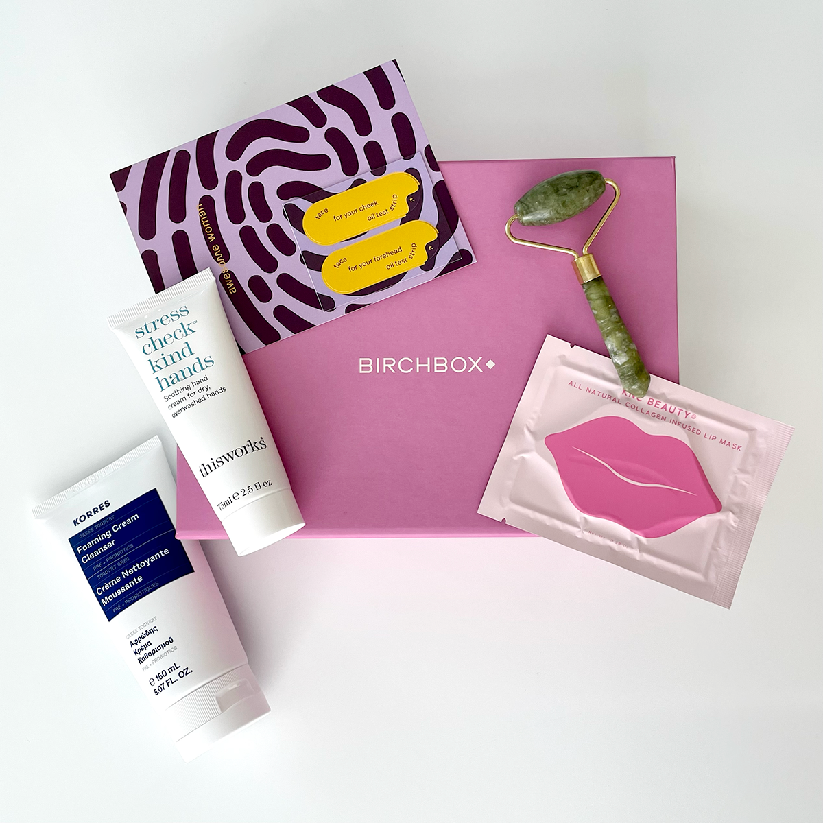 4 beauty products resting on top of pink Birchbox box