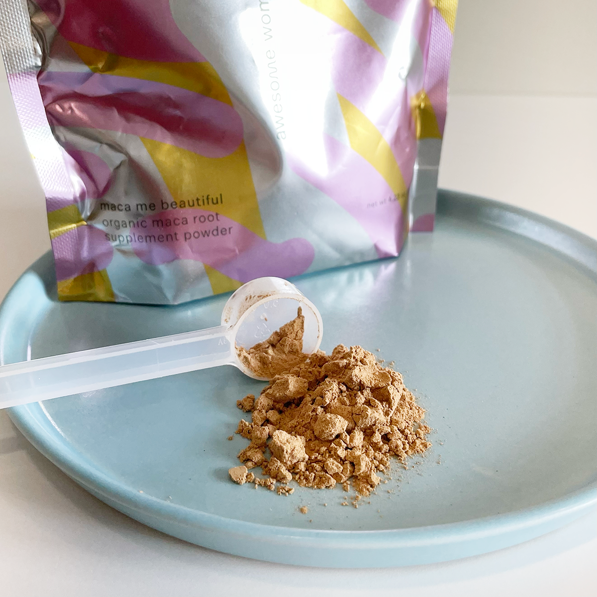 closeup of a scoop of maca powder with the bag in the background