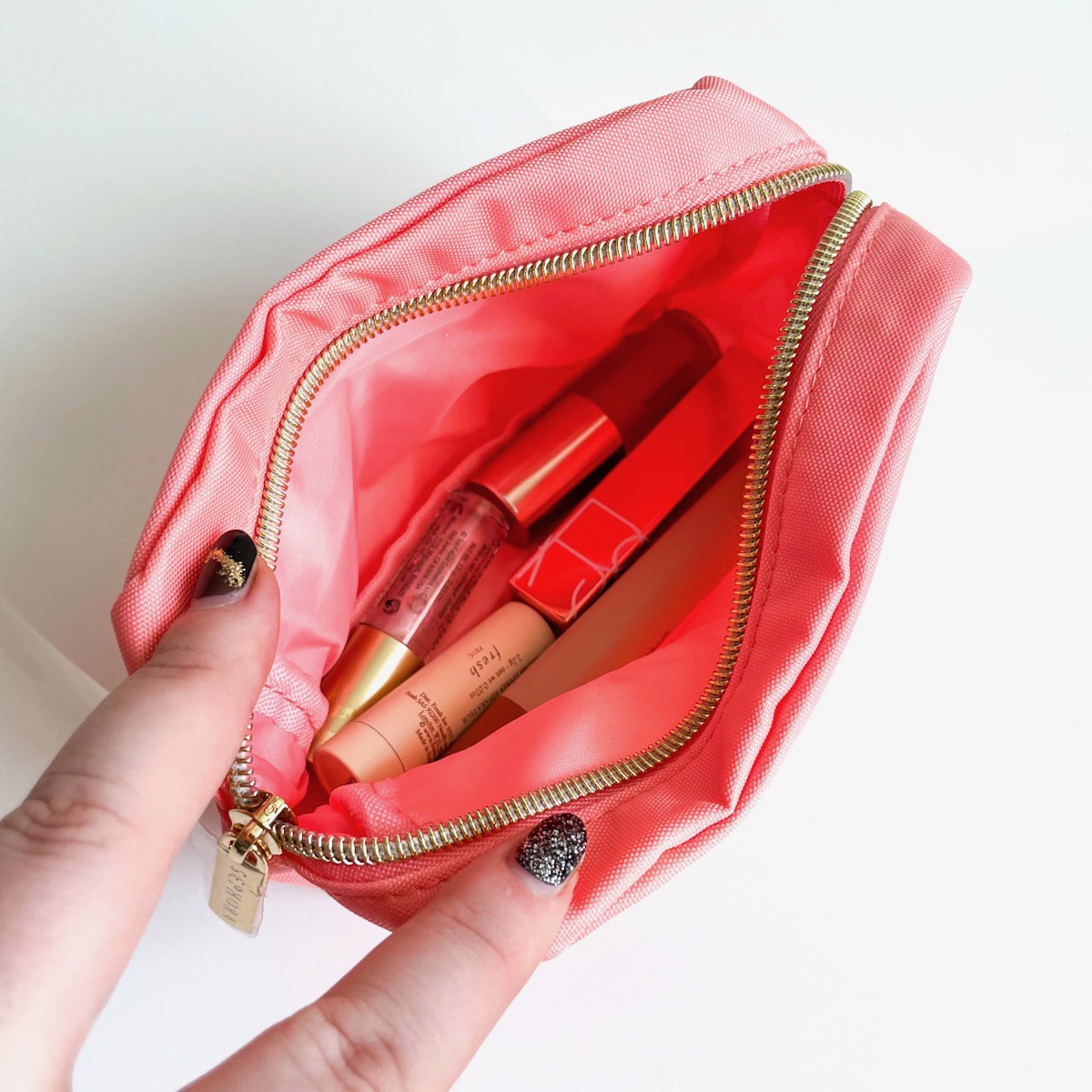 pink makeup bag, opened to show lip products inside