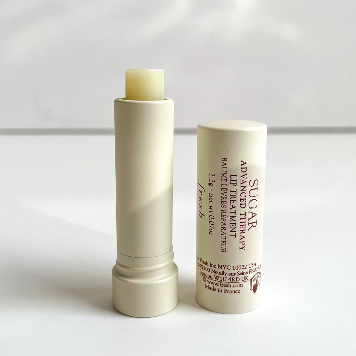 creamy white tube of lip balm, opened, showing off white lip balm texture