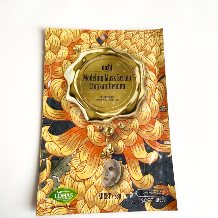 golden sheet mask with what looks like wax seal depicted