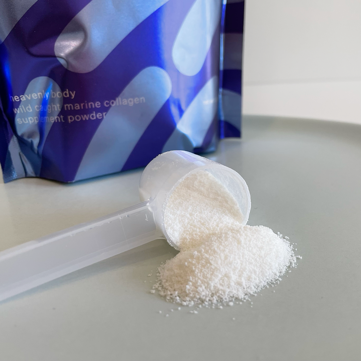 closeup of a scoop of marine collagen powder with the bag in the background