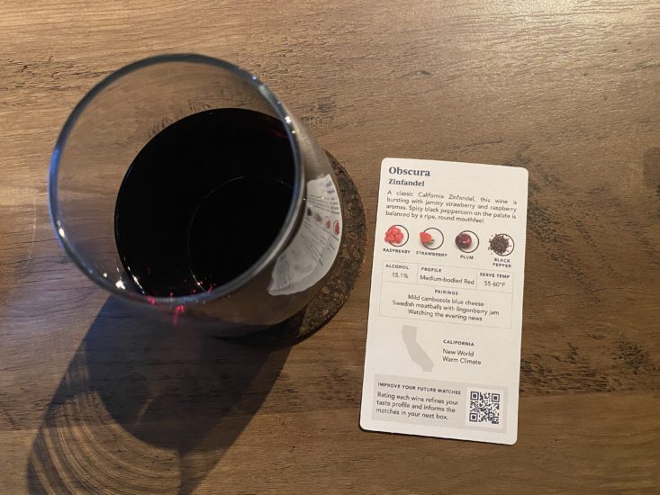 glass of zinfandel next to card describing tasting notes