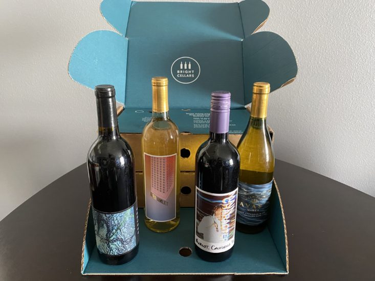 four bottles of wine in front of blue Bright Cellars cardboard box