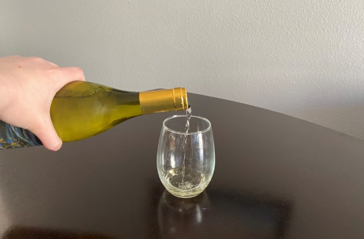 pouring bottle of wine into glass