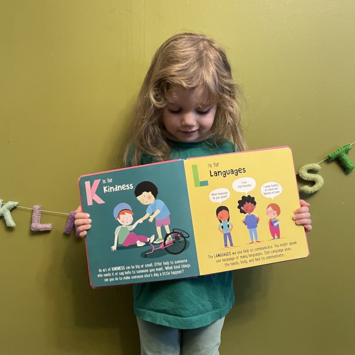 Kid looking down at open Little Feminist book