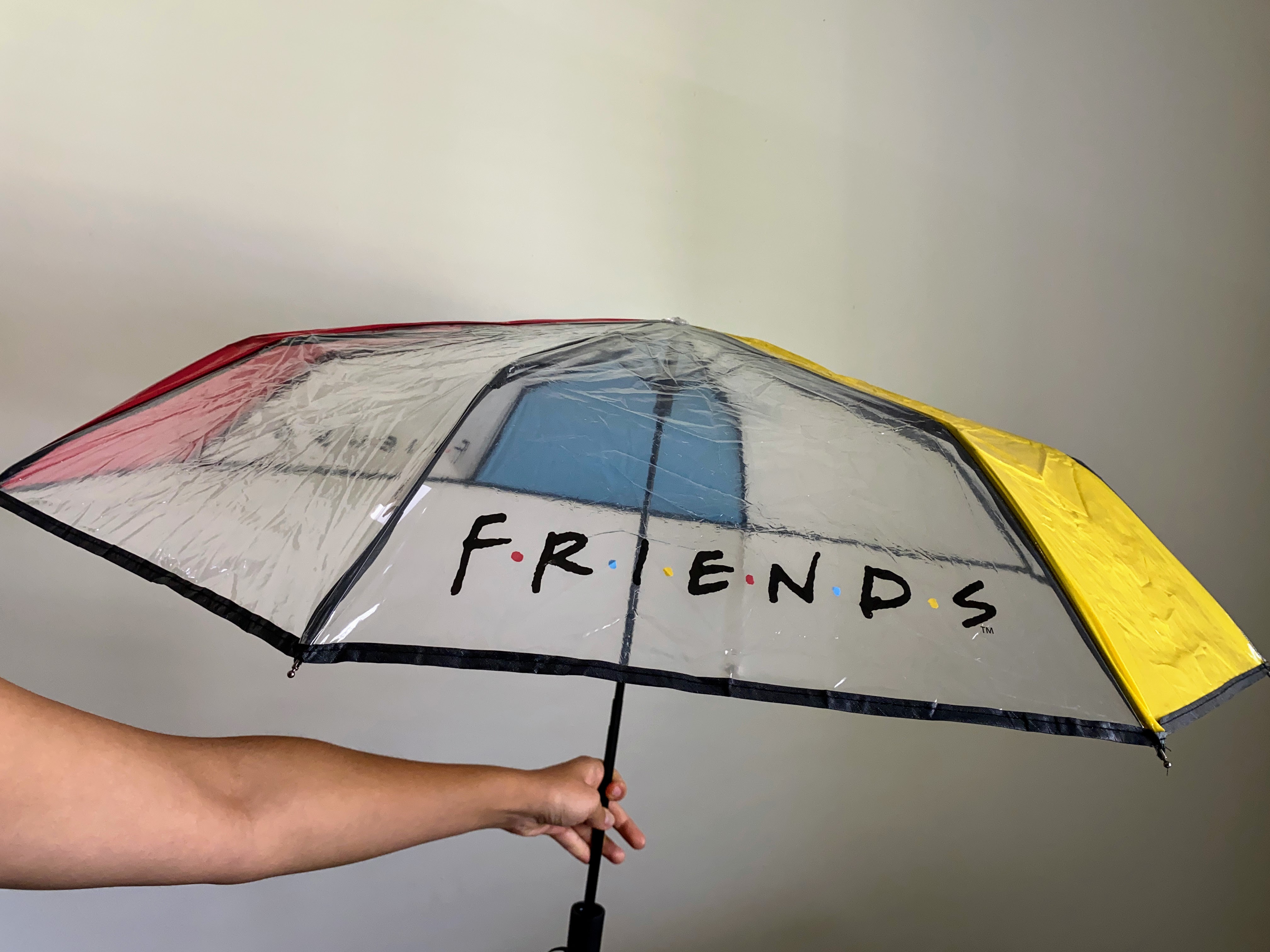 arm holding an umbrella with the friends logo