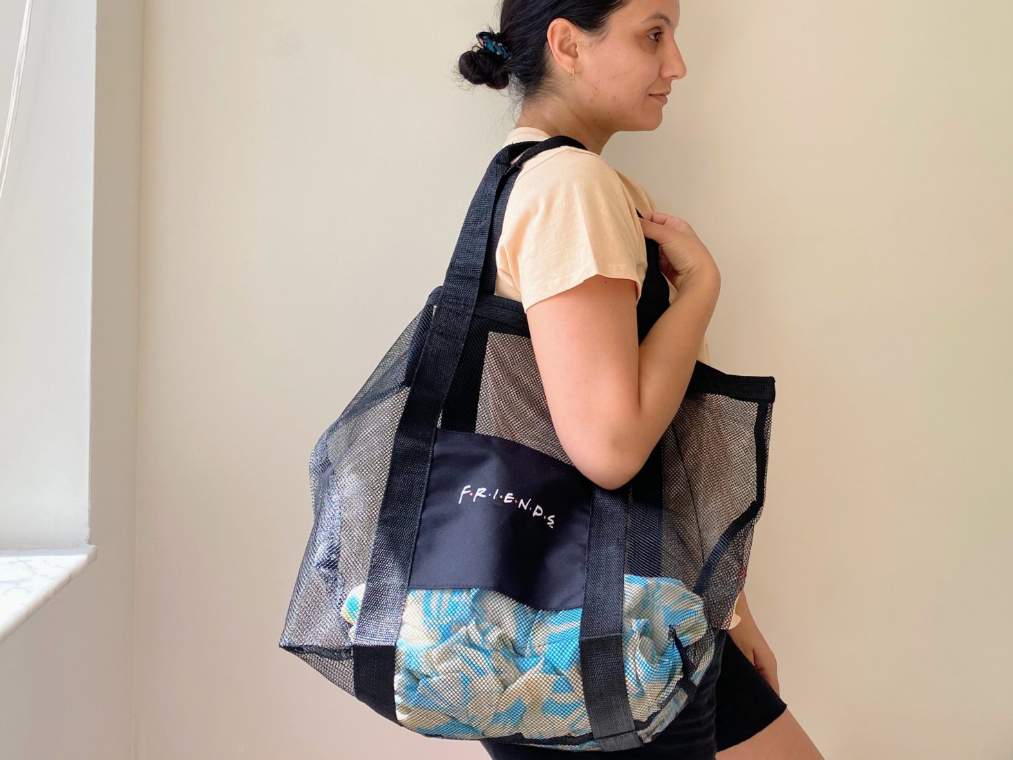 woman holding mesh beach tote bag