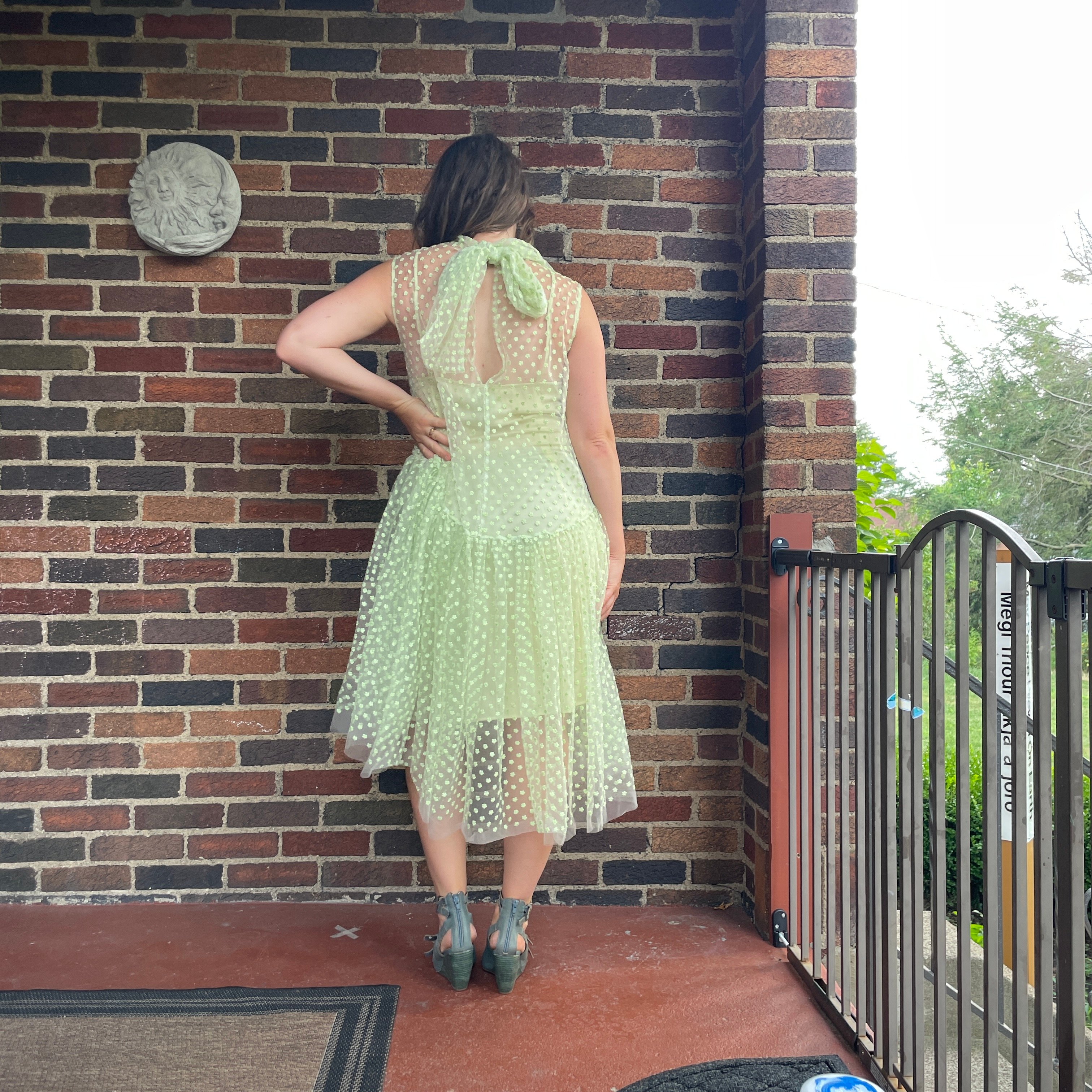 reviewer wearing lime green asymmetrical nuuly dress