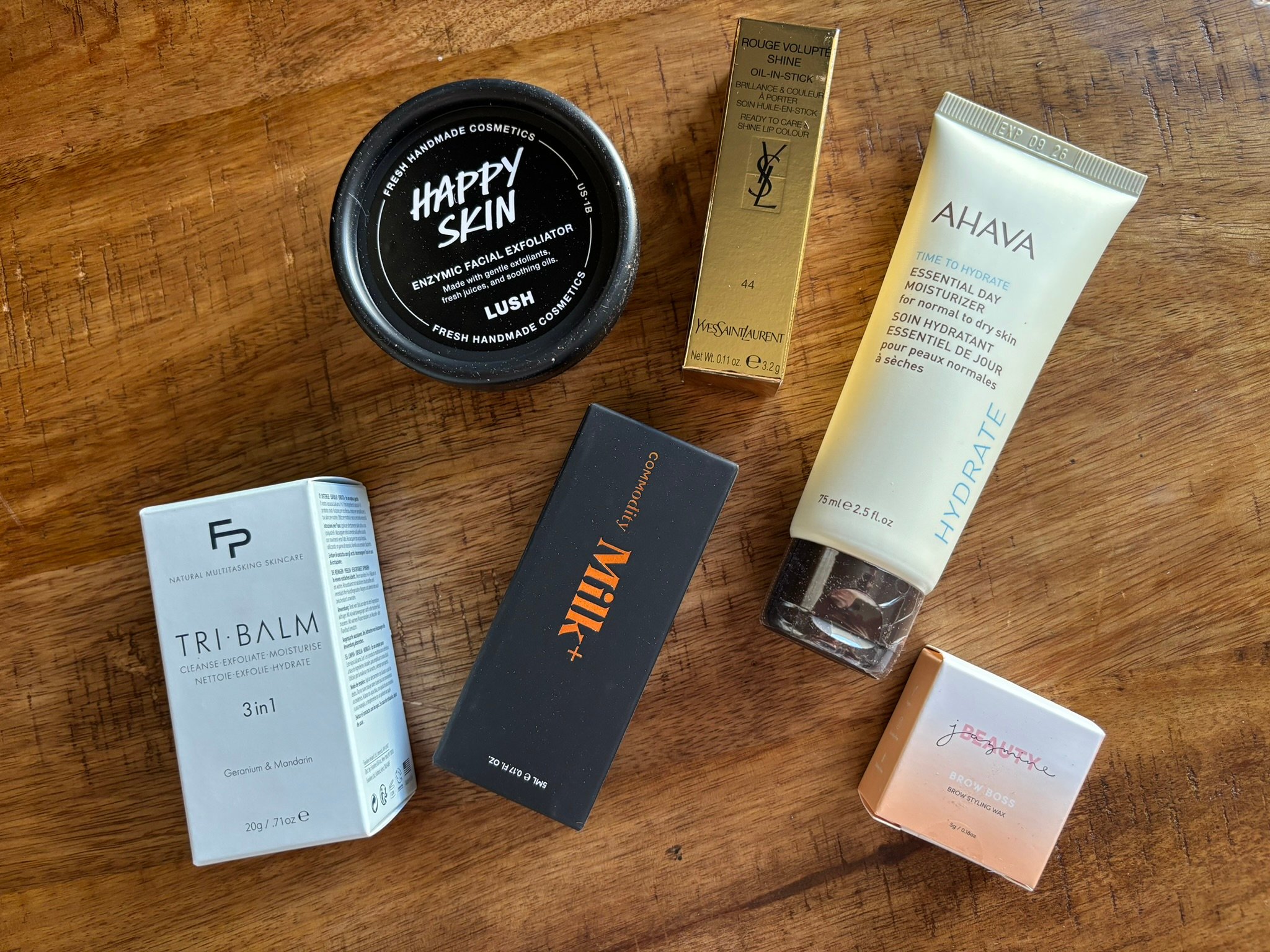 6 beauty and skincare products on a wood surface