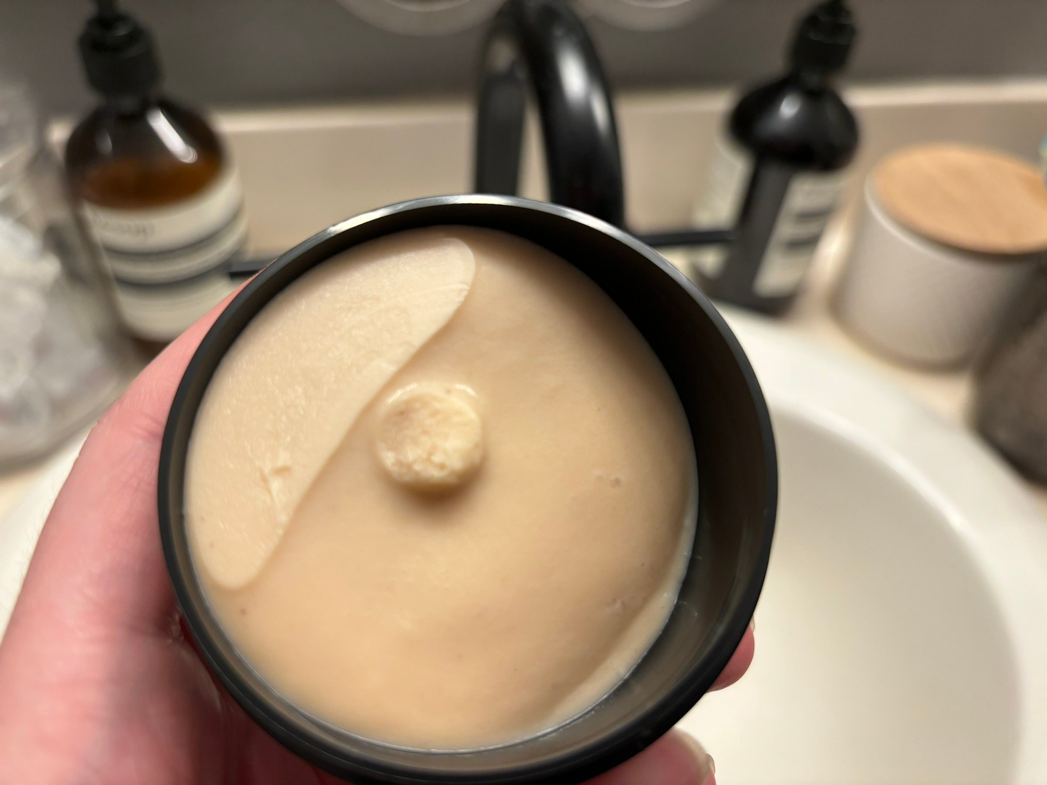 exfoliator cream inside a black tub
