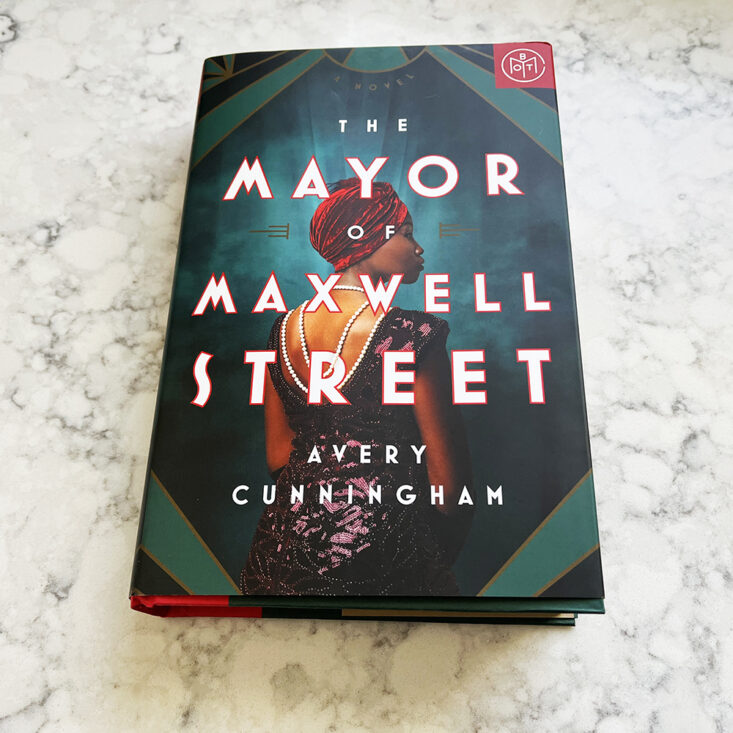 the book mayor of maxwell street from book of the month club sits on a countertop