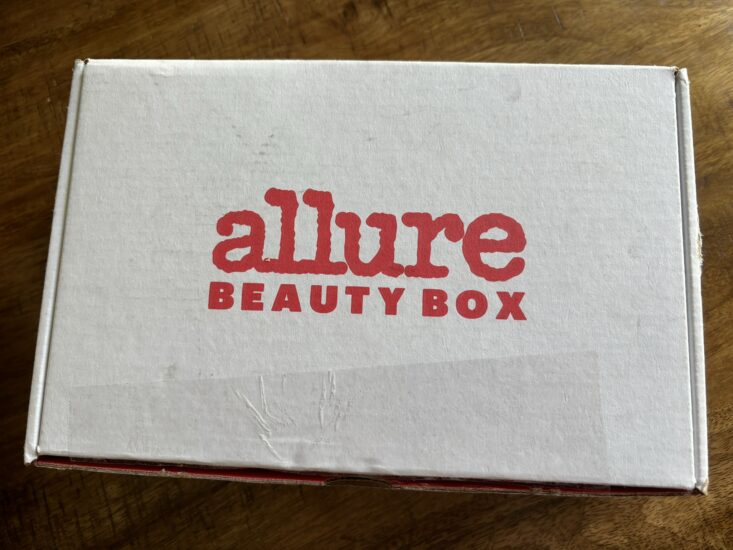 white cardboard box with "Allure Beauty Box" written in red