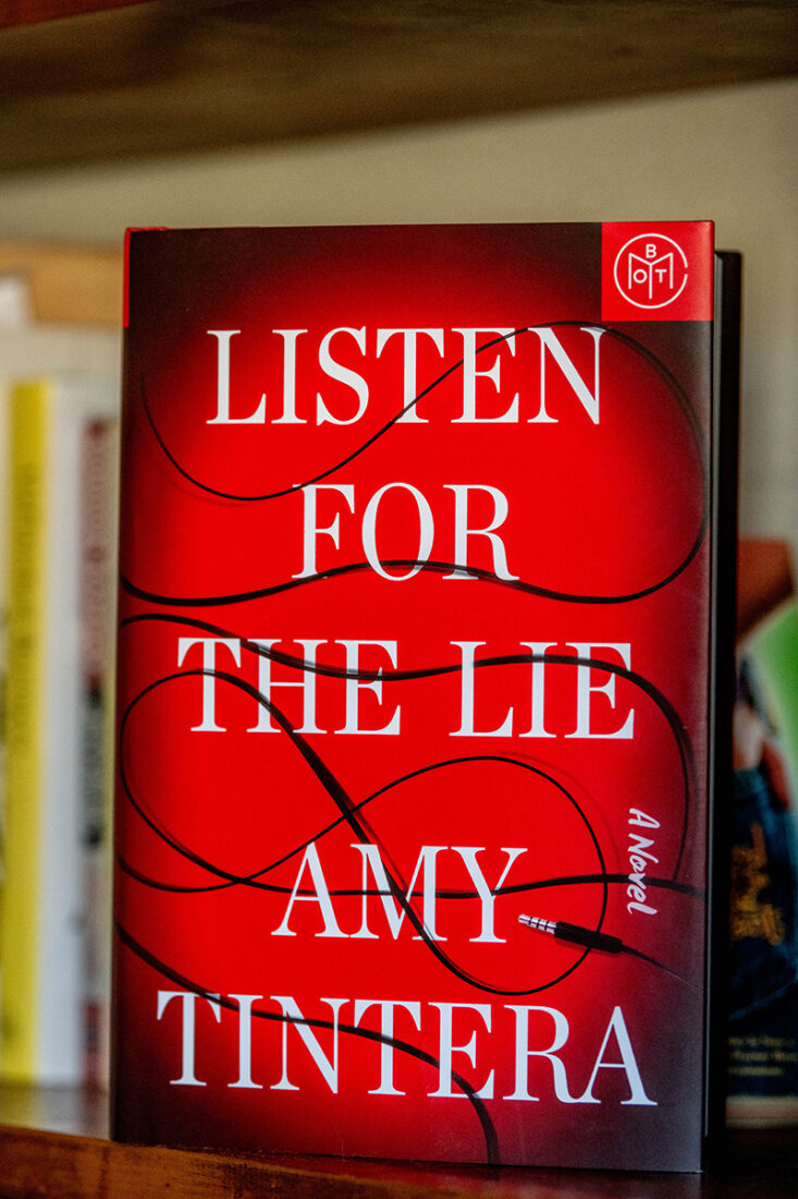 The book Listen for the Lie by Amy Tintera sits on a bookshelf. 