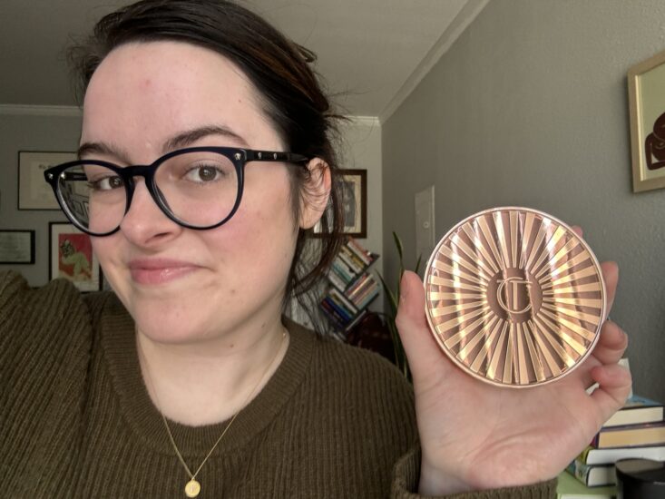 author Paige Bennett wearing Charlotte Tilbury bronzer and holding bronzer compact