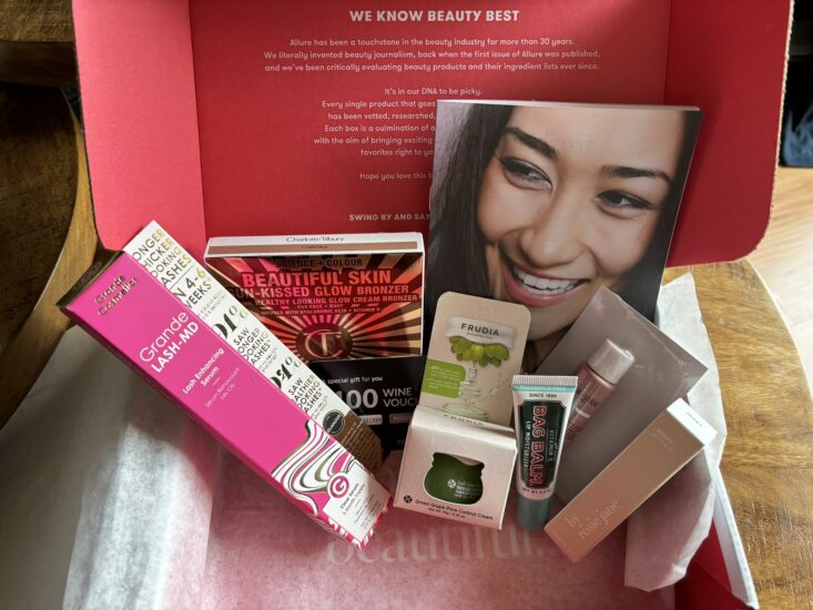 Allure Beauty Box with lash serum, pore cream, hair gloss, lip balm, perfume, and bronzer inside